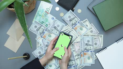 online investments, success concept. internet investments. making money. online auction winner, monetary victory concept. smartphone with green screen. woman using mobile app for investing