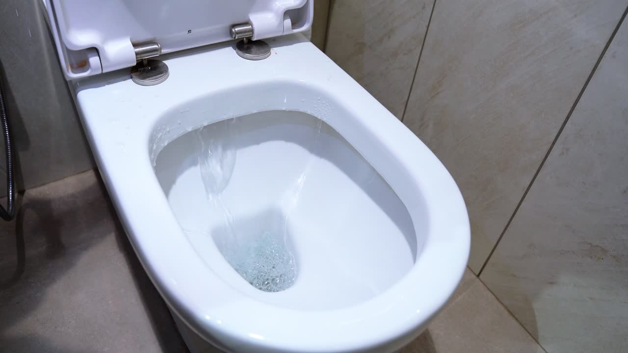 Top-down view of a flushing toilet with visible water swirl. Great for plumbing, sanitation, or hygiene campaigns.