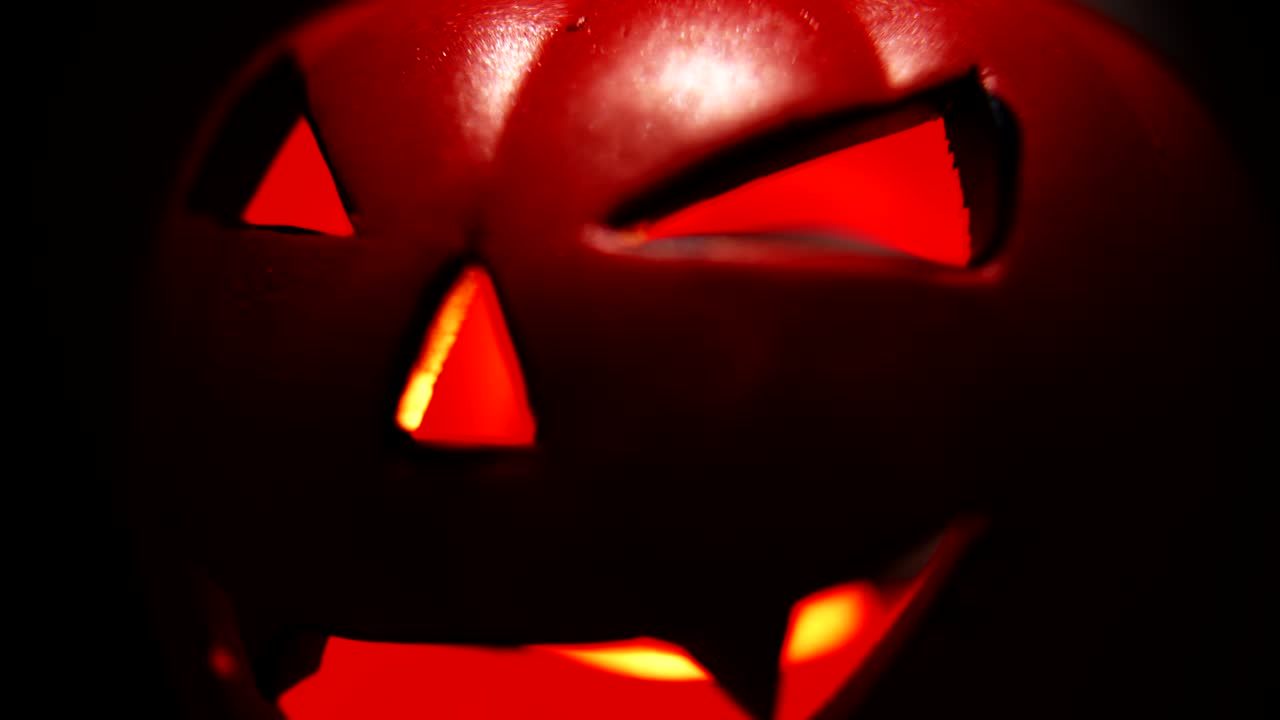 Inquietante faccia di zucca di Halloween che si illumina di rosso nel buio