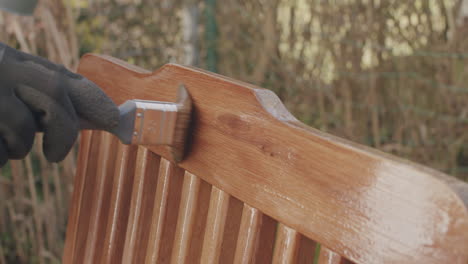 Putting-linseed-oil-onto-the-top-of-a-wooden-chair-with-a-brush