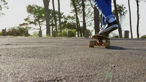 Rear-view-of-young-male-skateboarder-riding-on-skateboard-on-country-road-4k