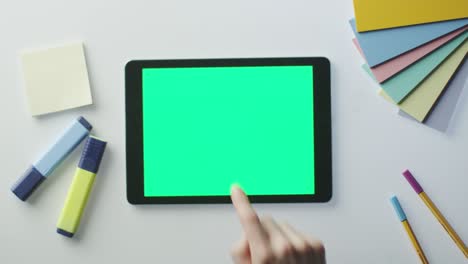 using tablet with green screen on designer's table.