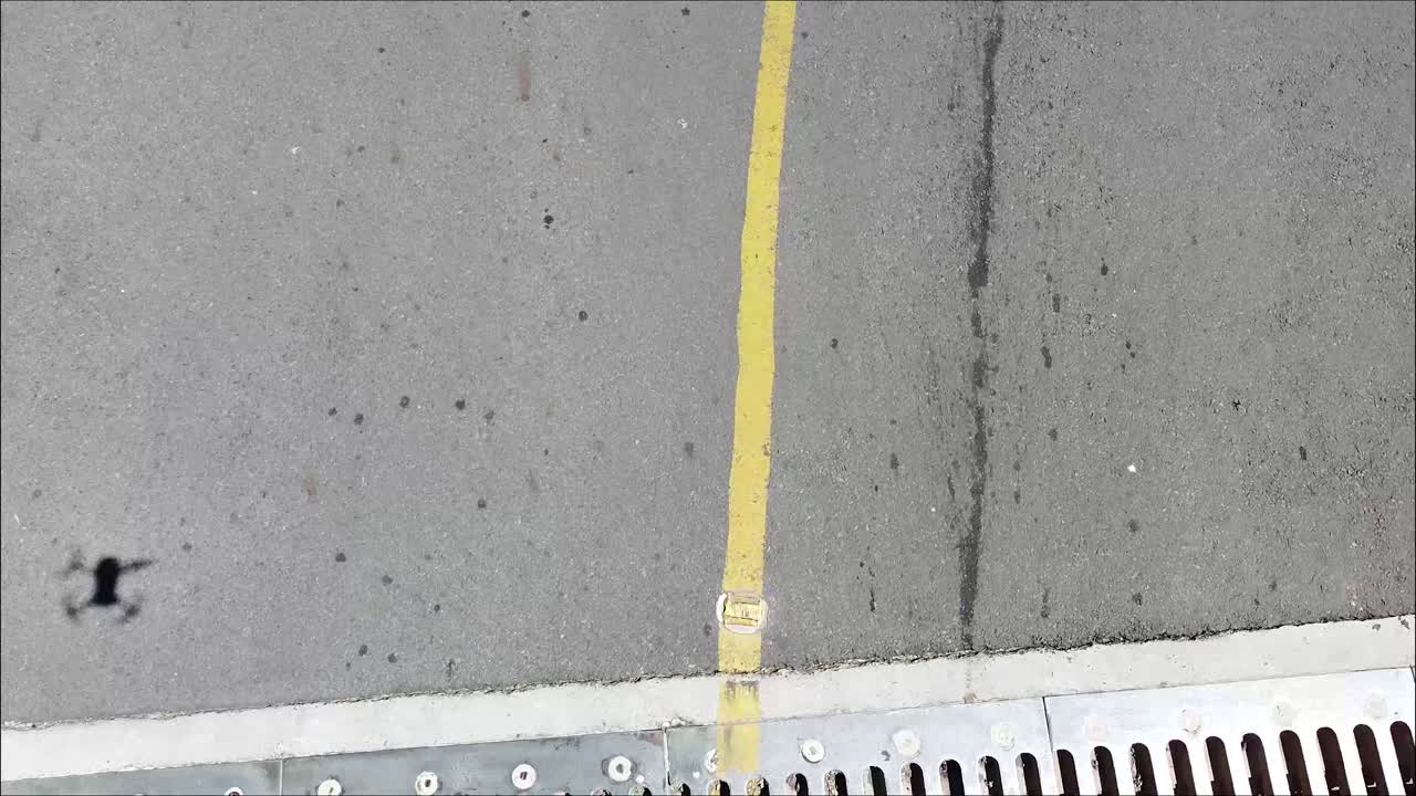 aterrizaje del avión no tripulado largo puente de cemento sobre el depósito, sombra del avión no tripulado