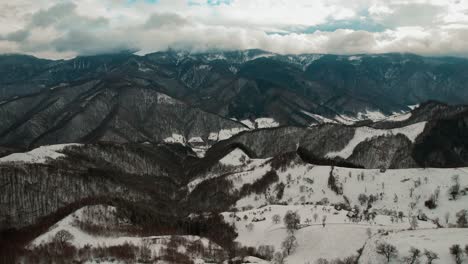 montañas de ceniza cubiertas de nieve bajo un dramático cielo nublado, vista aérea