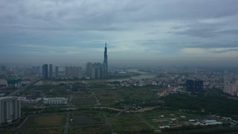 Vuelo-Largo-Hacia-El-Río-Y-El-Desarrollo-De-La-Ciudad-Moderna-Con-Torres-De-Gran-Altura-Temprano-En-La-Mañana