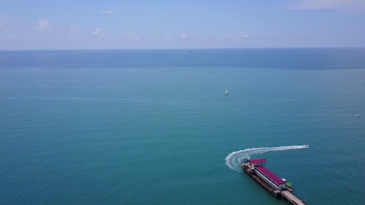 Boat in the sea departs from the pier and fast sailing along the coast