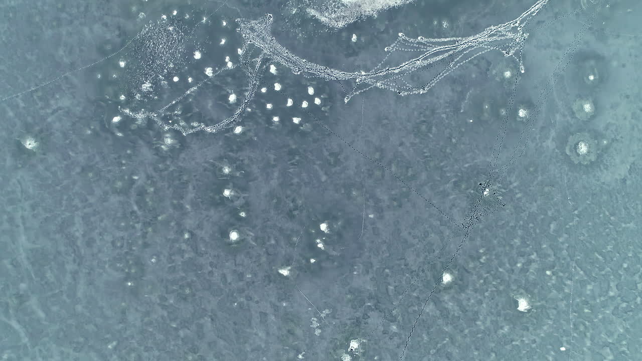 낮에 겨울 풍경에 은행에 눈 덮인 나무와 함께 얼어붙은 푸른 호수의 아름다운 공중 하향식 샷