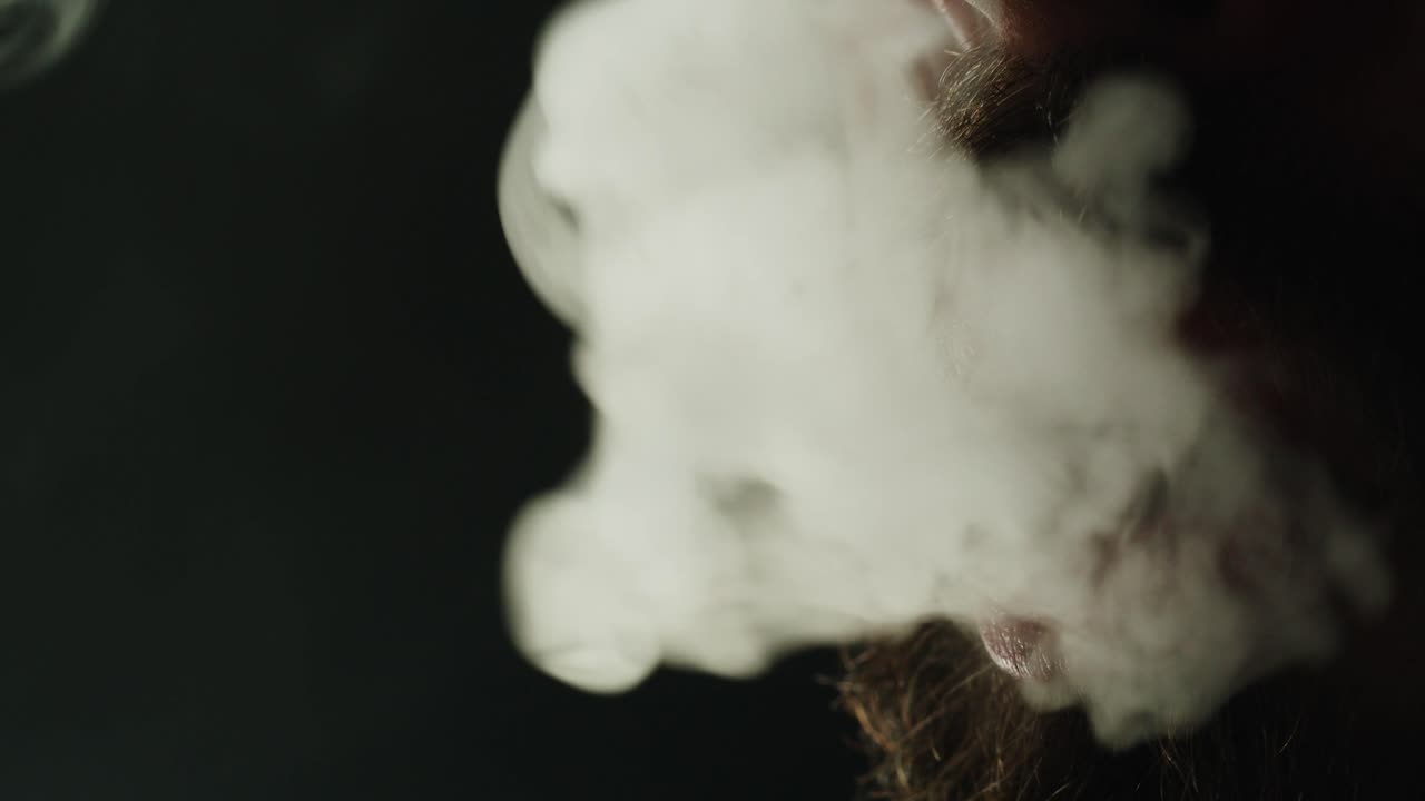 Close-up of Bearded Man Exhaling Thick White Smoke
