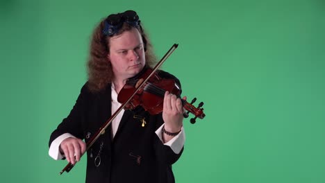 un violinista con un traje negro y gafas originales en la cabeza toca el violín con maestría. el hombre toca las cuerdas con un arco para crear una melodía. pantalla verde tecla de croma. cámara lenta.