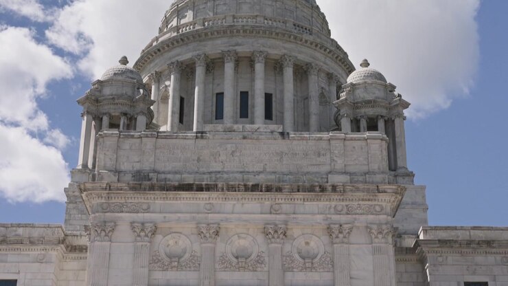 Panoramica verticale cinematografica verso il basso dalla cupola di marmo della Rhode Island State House contro un cielo estivo di un blu intenso nel centro di Providence, Rhode Island.