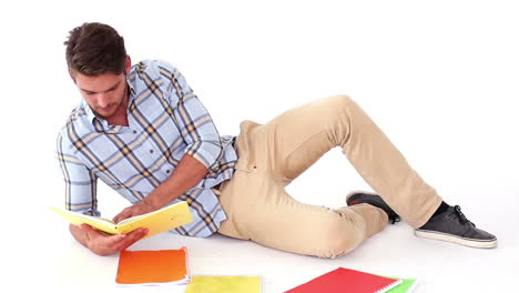 Handsome-young-student-studying-on-floor