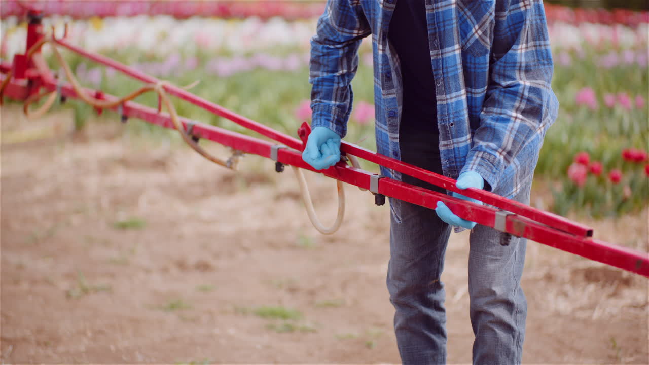 Farmer Adjusting Sprayer Boom in Agricultural Field