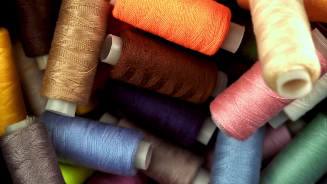 Colorful Spools of Thread Falling and Settling