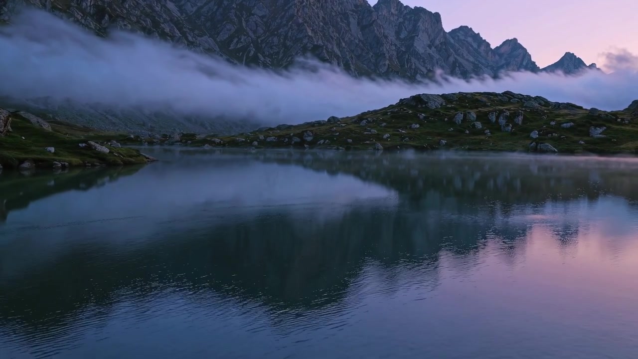 Majestic Alpine Lake Reflecting Mountains and Clouds at Dawn