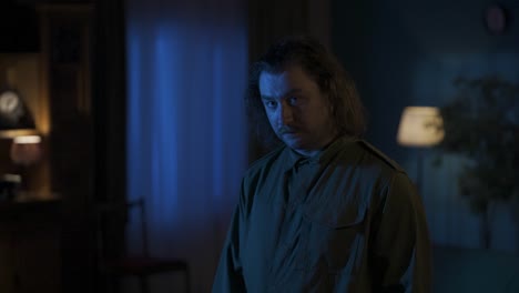man with a baseball bat in a dark room