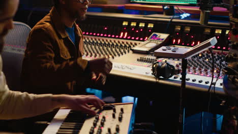 musician artist playing midi controller synthesizer in recording music studio