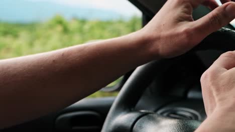 Detalle-De-Cerca-De-Las-Manos-De-Un-Hombre-Conduciendo-El-Coche-En-Cámara-Lenta