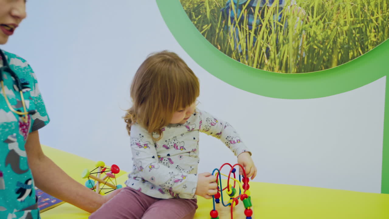 Doctor examining little girl. Cute woman pediatrician examining of girl kid