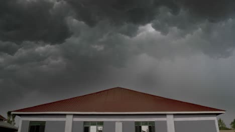 un relámpago sobre una casa con oscuras nubes de tormenta amenazantes rodando