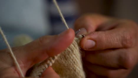 Manos-De-Anciana-Tejiendo-Calcetines-De-Lana-Hechos-A-Mano-Con-Agujas-En-Casa,-Cámara-Lenta,-Cerca-De-La-Abuela