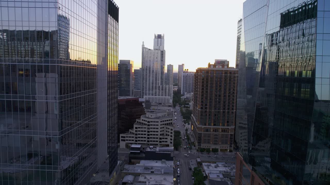 vista aérea que revela la calle west 4th, entre edificios reflectantes en austin, puesta de sol en ee. uu. - seguimiento, disparo de drones