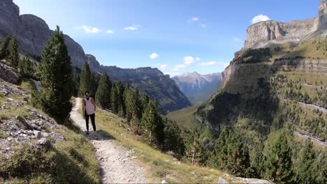 hiker walking along the senda de los cazadores in the ordesa valley, huesca, spain