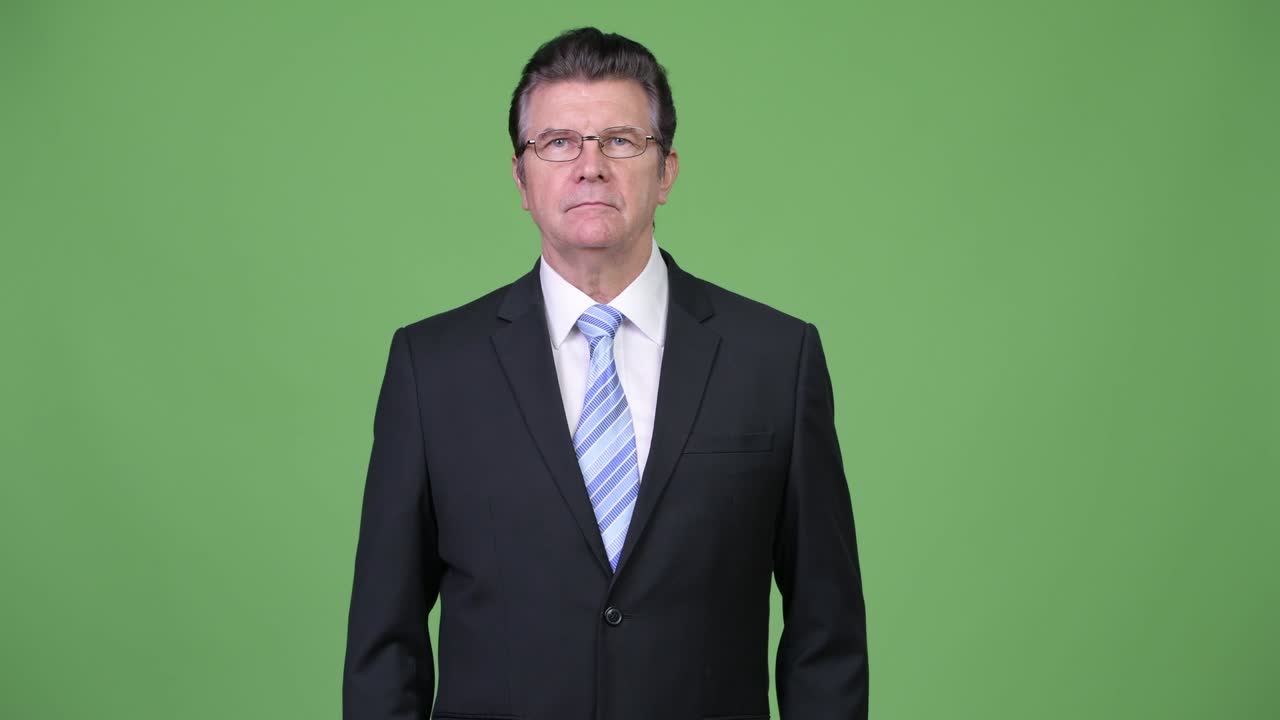 Senior handsome businessman gesturing stop