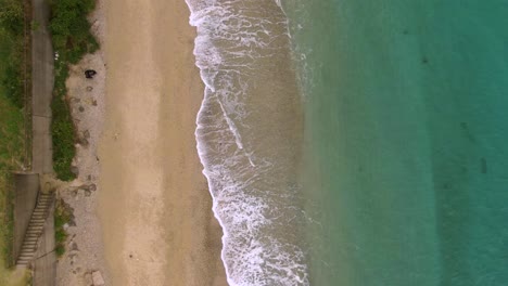 Suaves-Olas-Rompiendo-En-La-Prístina-Playa-De-Amami,-Japón---Vista-Aérea-De-Arriba-Hacia-Abajo