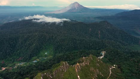 aerial view of mount sibayak ridge tilting up to mount sinabung in the distance - north sumatra, indonesia