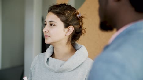 Cute-young-woman-listening-her-colleague