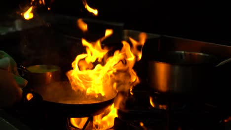 Slowmo---Koch-In-Einer-Luxusrestaurantküche,-Der-Meeresfrüchte-Auf-Der-Flamme-Brät---Nahaufnahme