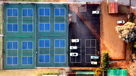 top down abstract aerial over four pickleball courts with people playing