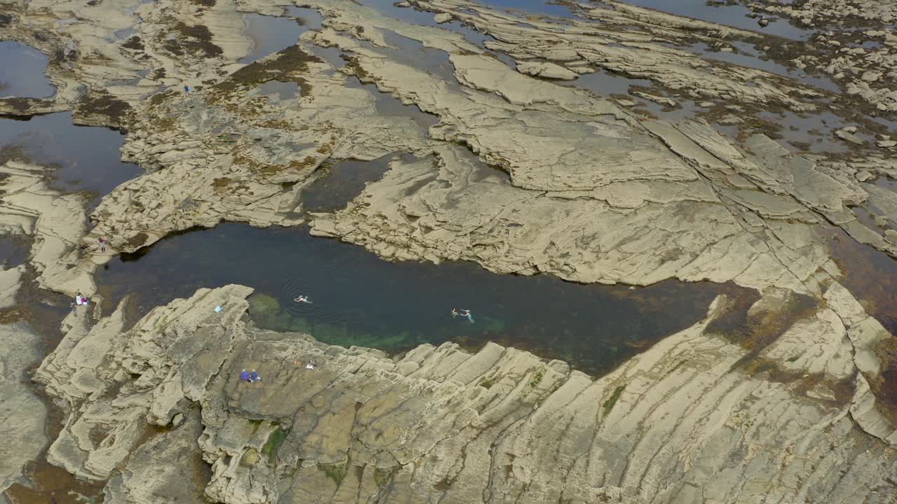 Tidal pool at Pollock Holes on the Clare coast, with swimmers enjoying the waters.