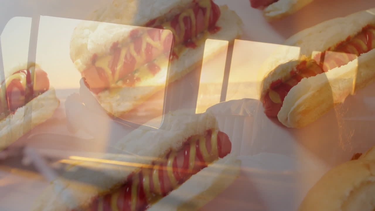 Overlaying sunset view from window, hot dogs with ketchup and mustard