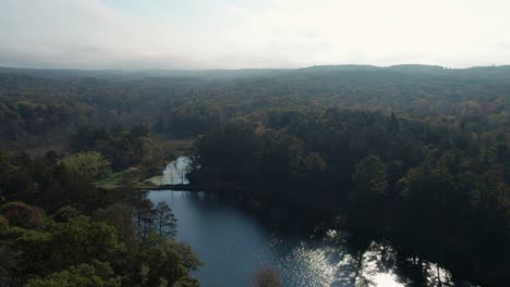 Aerial-drone-shot-of-a-river-on-a-hazy-summer-day-in-the-Midwest,-US