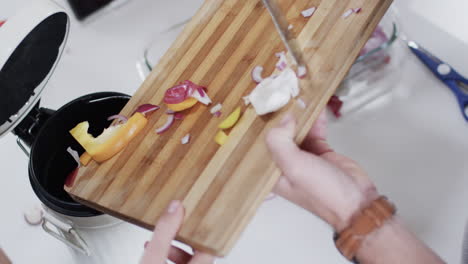 midsection of diverse couple cleaning vegetable peelings in kitchen, slow motion