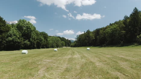 Landscape-pan-shot-of-hayballs-in-the-field