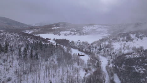 Winter-cabin-Aspen-Snowmass-Pitkin-county-wilderness-aerial-drone-Rocky-Mountains-Colorado-Basalt-Carbondale-Sopris-Maroon-Bells-Ashcroft-Independence-Pass-cloudy-foggy-snowy-morning-forward-motion