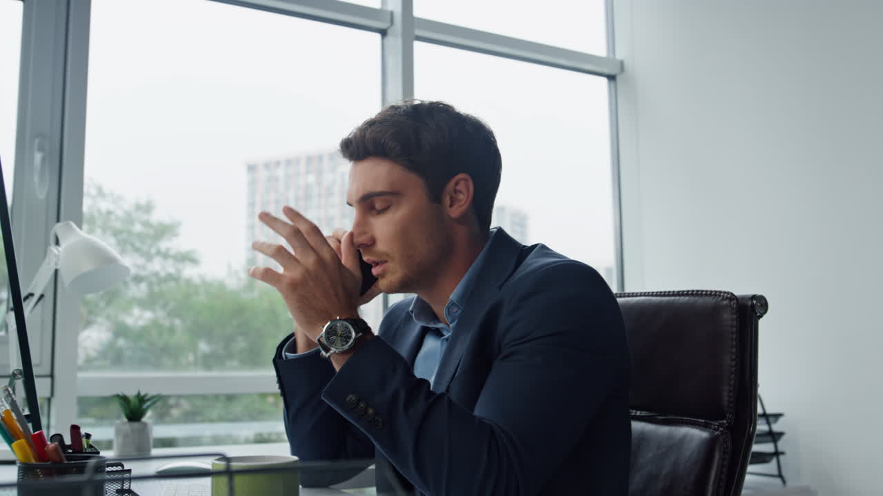 Manager serio che parla al cellulare sul posto di lavoro. Venditore preoccupato che parla.