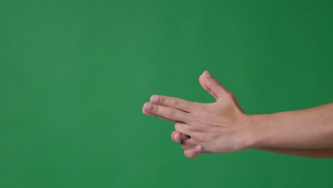 hand making shoot gesture over green background