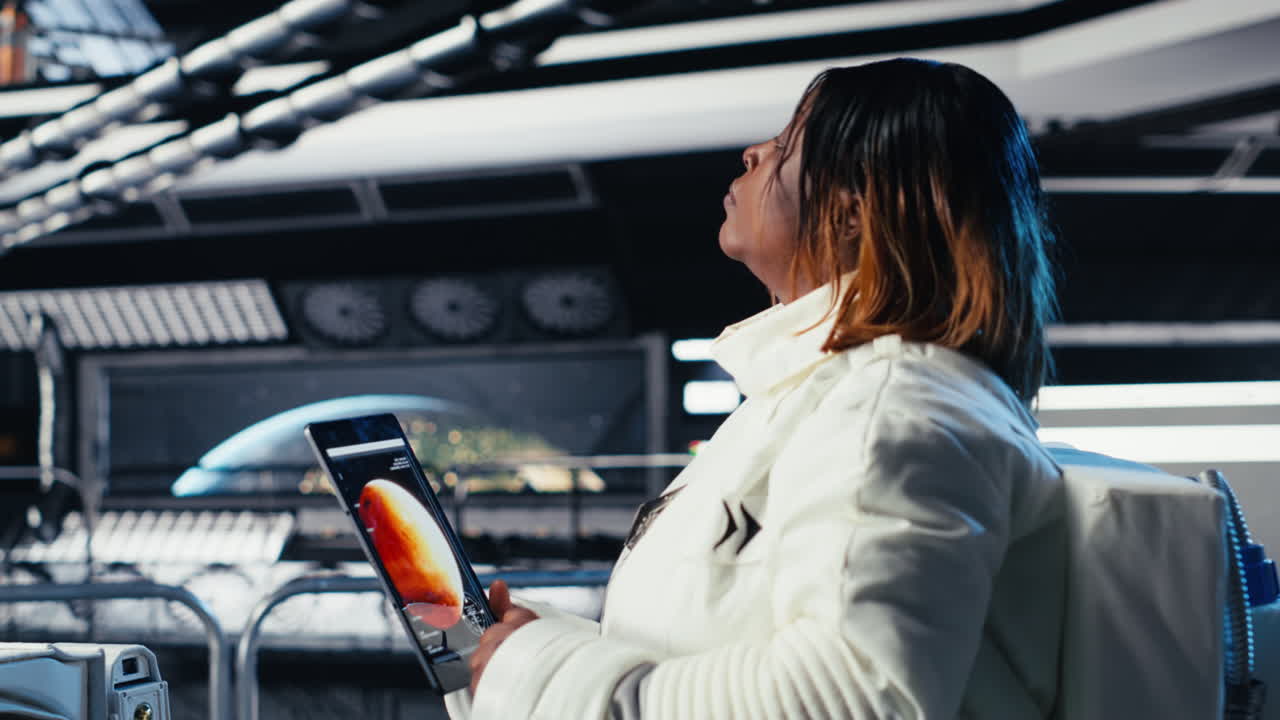 Astronaut using tablet to check analytics after completing Mars mission