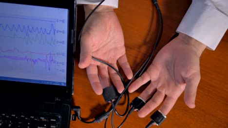 man's hands connected to the lie detector circuit.