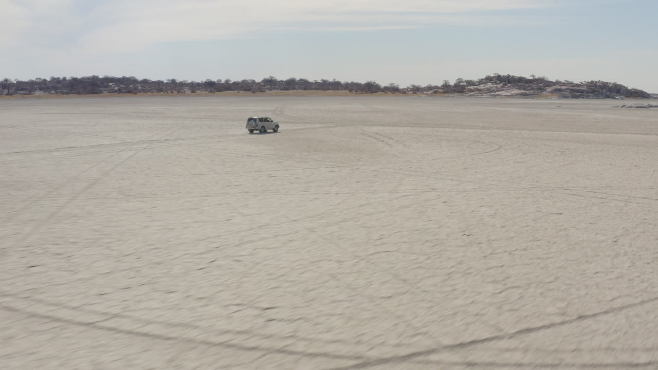 남아프리카 공화국 보츠와나의 쿠부 섬을 향해 막가디카디의 마른 염전에서 운전하는 4x4 자동차