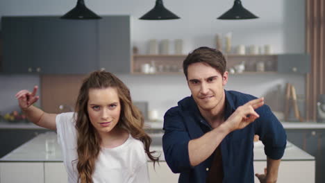 hombre y mujer bailando en la cocina.