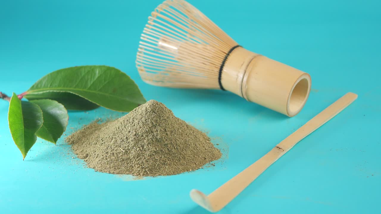 Polvere e strumenti per il tè Matcha tradizionale su sfondo turchese