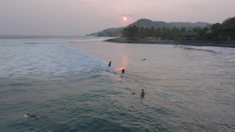 vista aérea dos surfistas compartiendo ola al atardecer sunzal el tunco el salvador