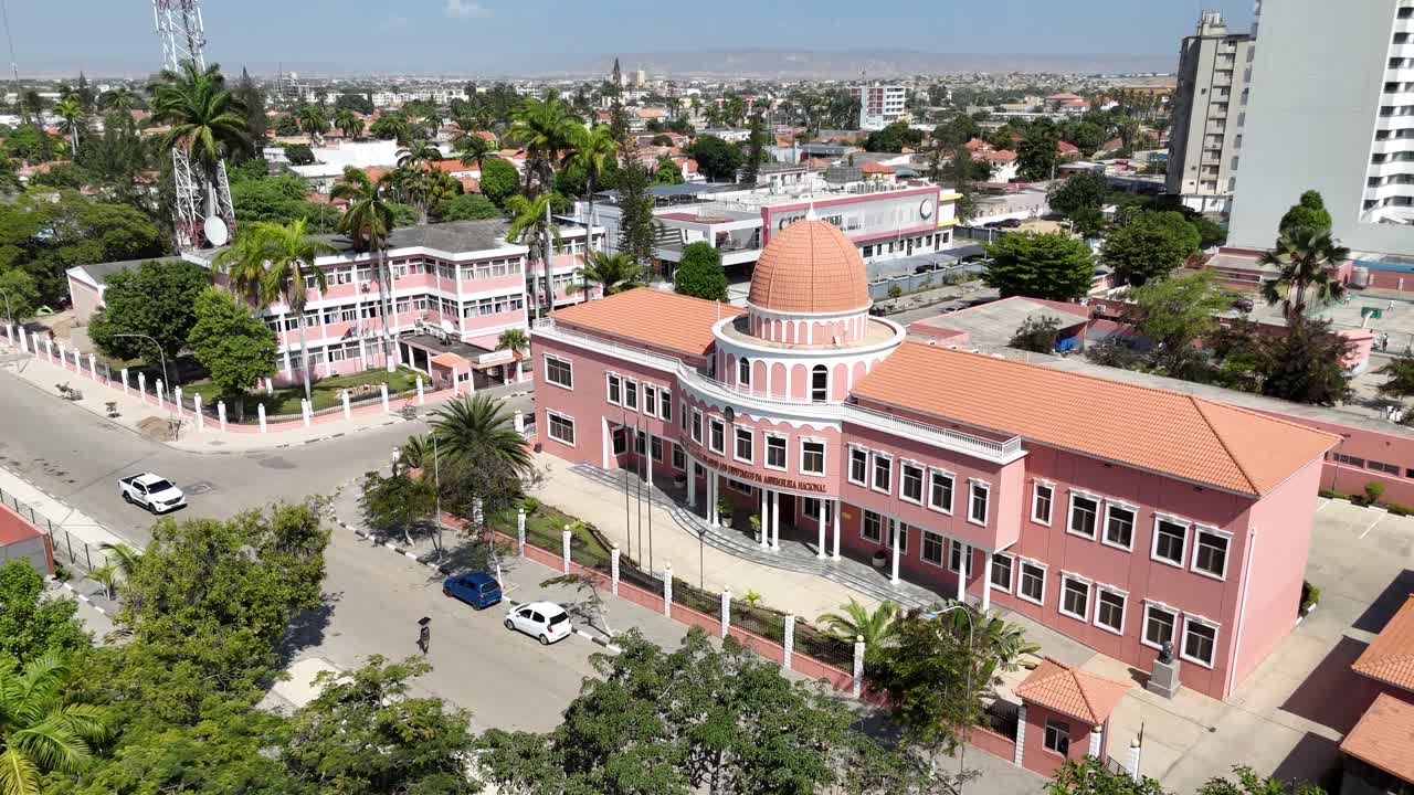 Aerial drone footage of Benguela city, Angola, highlighting pastel colonial architecture, palm trees, and streets close to the Atlantic seafront