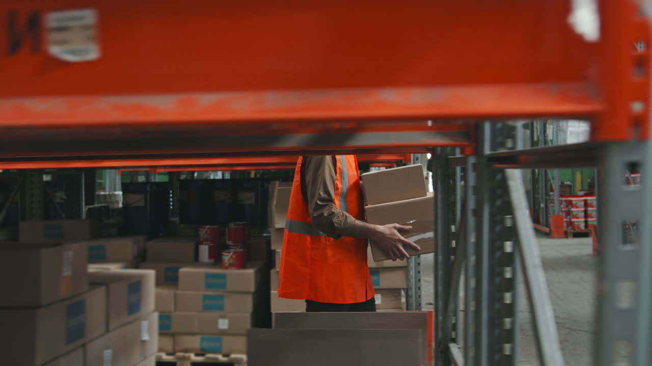 Worker with Boxes Walking Through Warehouse