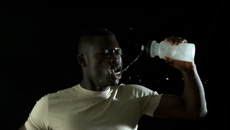 handsome man jogging and pouring water over himself