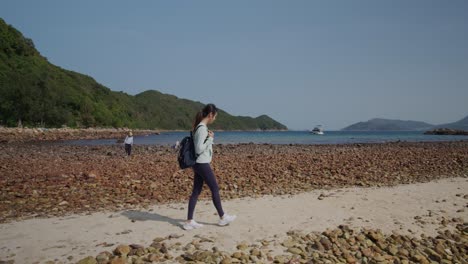 asiatische frau, die am meer spazieren geht